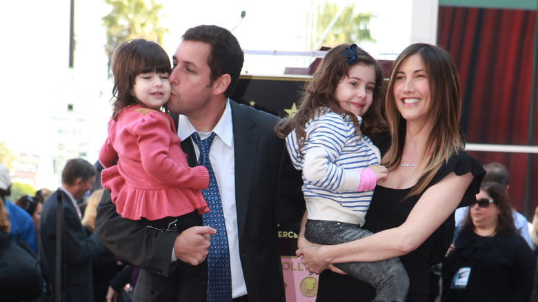 Adam Sandler holds Sunny Sandler and Jackie Sandler holds Sadie Sandler on the red carpet