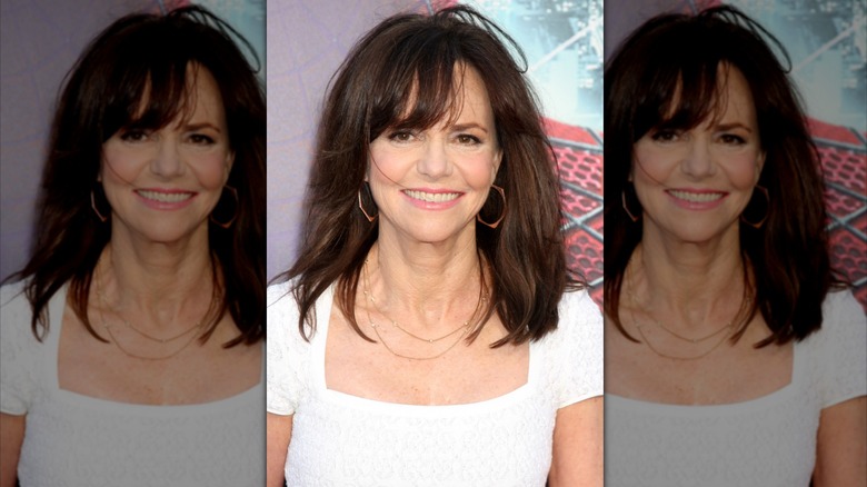 Sally Field in a white square cut dress and large hoops