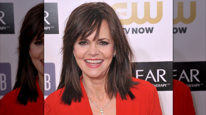 Sally Field in an red blazer and light coral lipstick