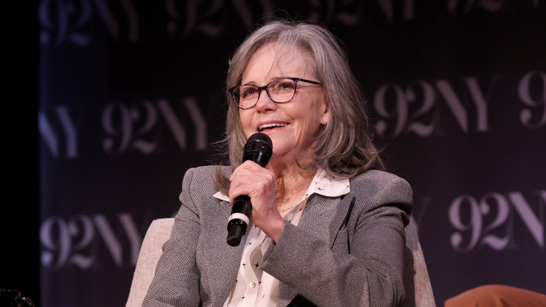 Sally Field in an grey blazer and holding a mic