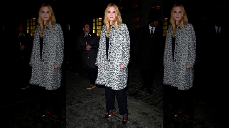 Nicole Kidman stopping for a photo while wearing a long, leopard-print coat over a black outfit