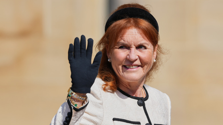 Sarah Ferguson waving at a crowd with a black headband