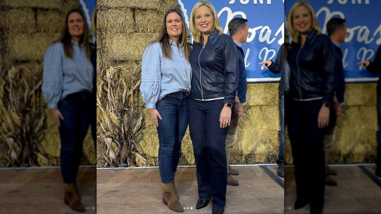 Sarah Huckabee Sanders standing next to another woman and wearing suede ankle boots tucked into skinny jeans