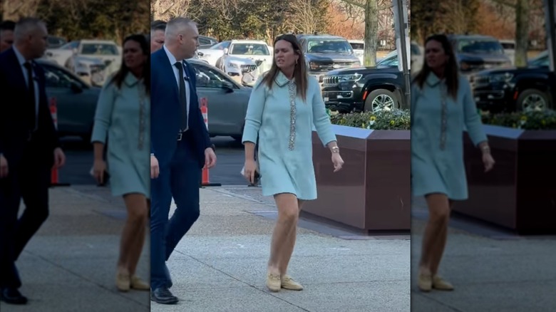 Sarah Huckabee Sanders walking in a light-blue mini dress and wearing yellow horse-bit mules