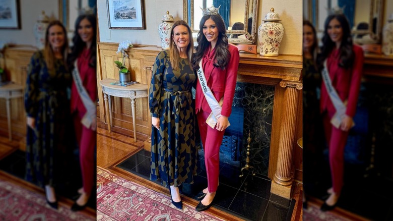 Sarah Huckabee Sanders standing next to a woman in a red suit with a crown and pageant sash