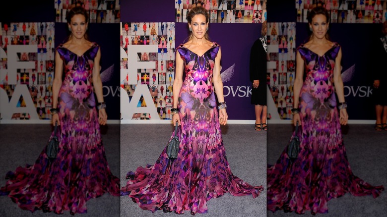 Sarah Jessica Parker smiles in a pink and purple print dress