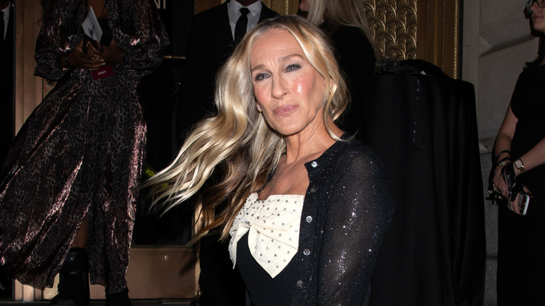 Sarah Jessica Parker flicks her hair in a black and white embellished dress
