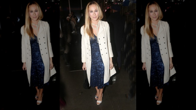 Sarah Jessica Parker smiles wearing a sequin dress, trench coat, and polka dot heels