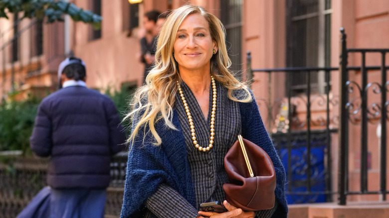 Sarah Jessica Parker in a blazer and overcoat with a pearl necklace outside