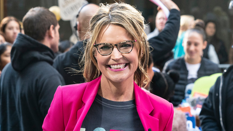 Savannah Guthrie smiling in a yellow and black floral print dress