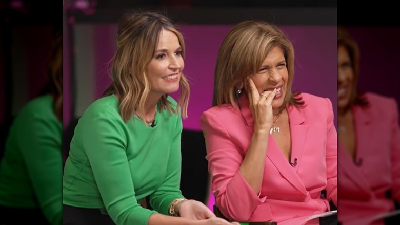 Savannah Guthrie, in a green top, sitting next to Hoda Kotb in a pink blazer