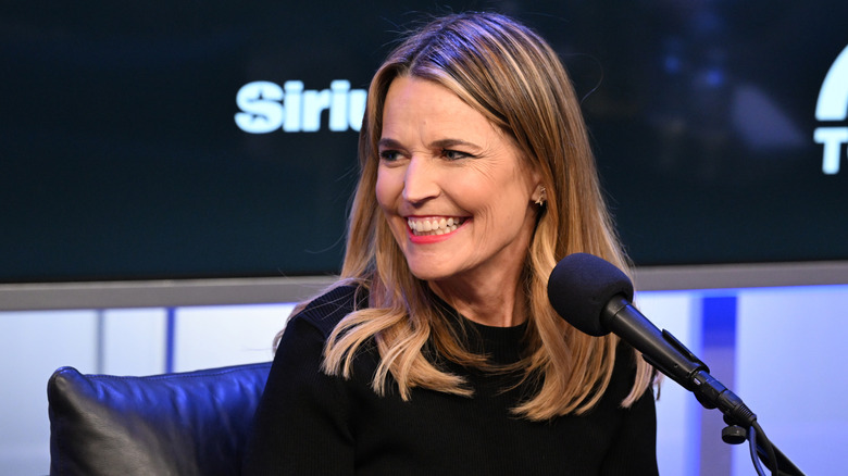 Savannah Guthrie smiling to the side while sitting in front of a microphone on SiriusXM