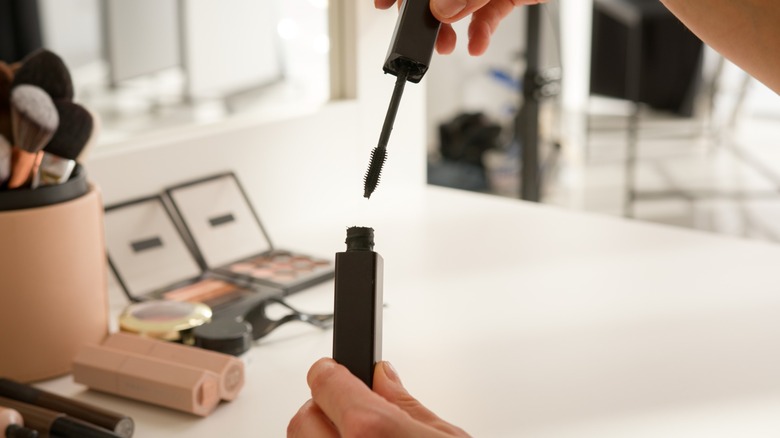 A person holding mascara