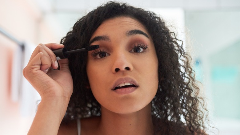 A woman applying mascara