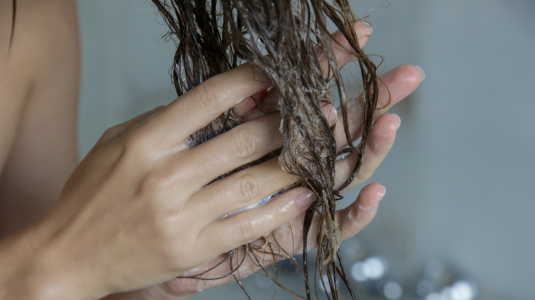 Woman conditions hair 