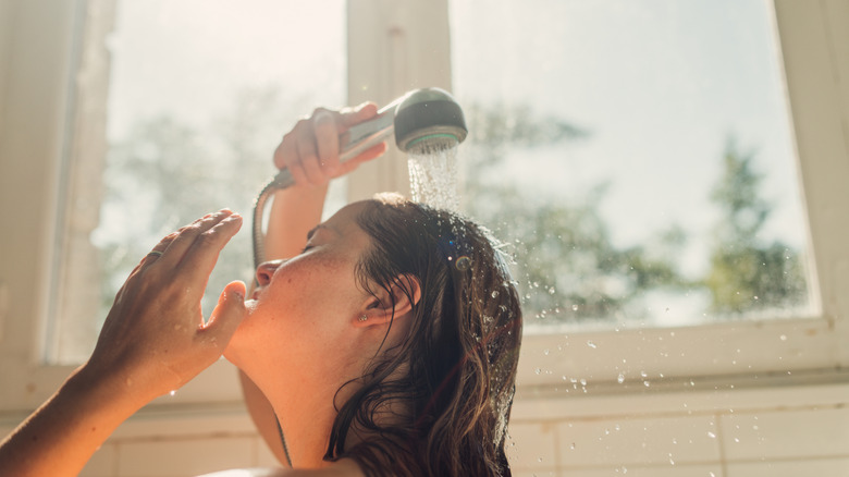 Woman washing her hair with shower head