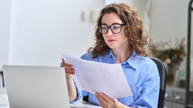 Woman reading papers at work