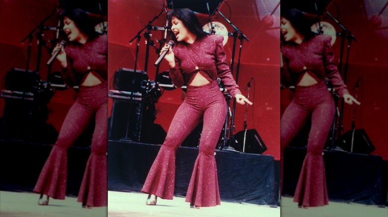 Selena perofmring in a sparkly red bodysuit with bodice cutouts