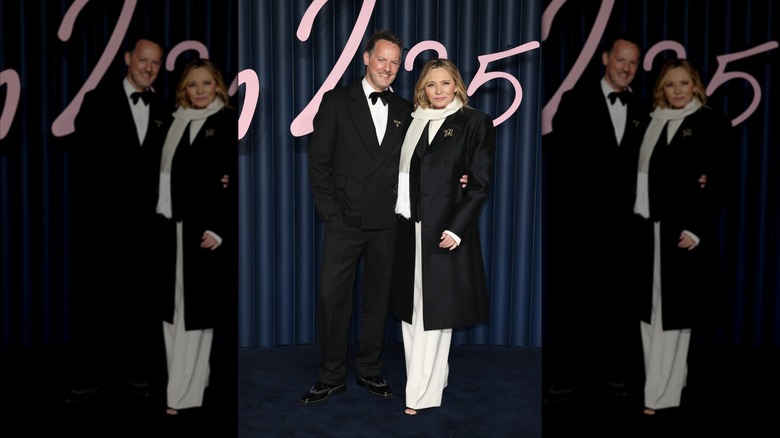 Kim Cattrall wearing black and white on the red carpet next to partner Russell Thomas
