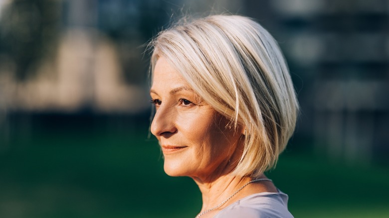 The side profile of an older woman with a soft textured bob