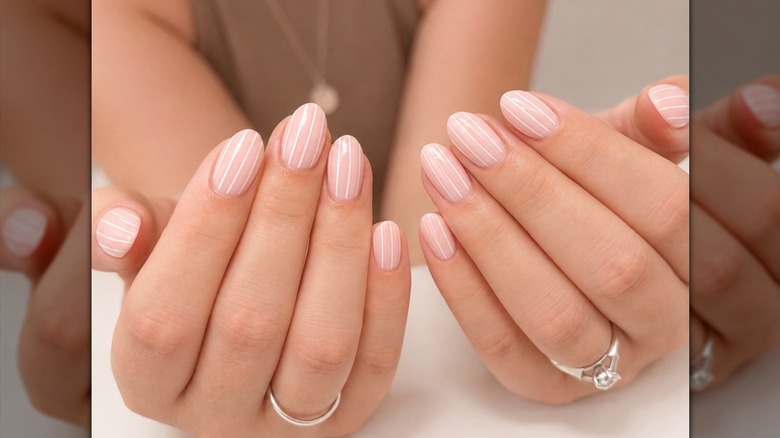 Pinstripe nails in baby pink with a white accent color