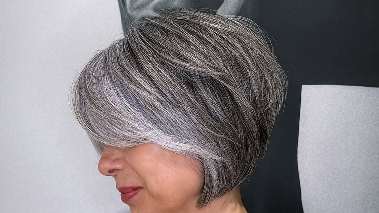 Woman wearing wedge hair cut with silver hair