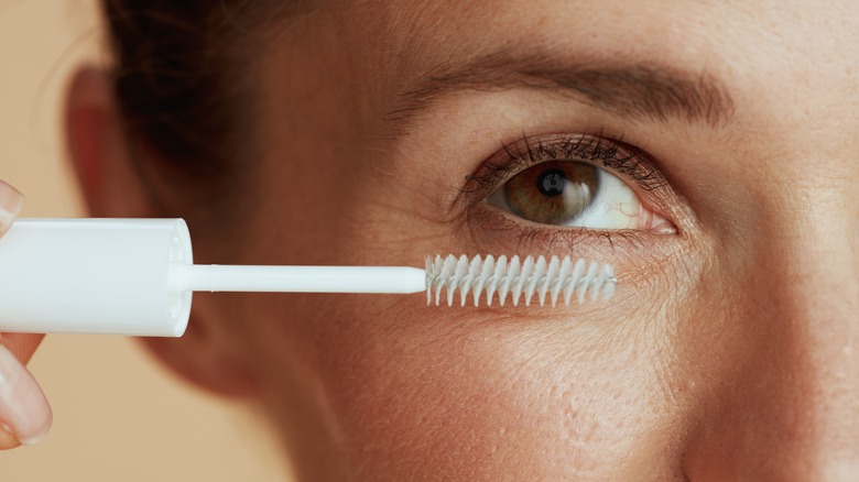 A woman using lash serum