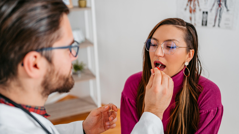 Doctor performs a cheek swab test on patient