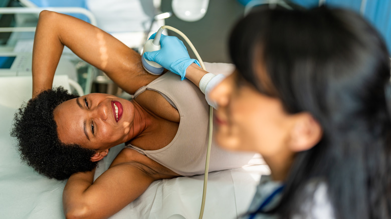 Doctor performs a breast sonogram on patient