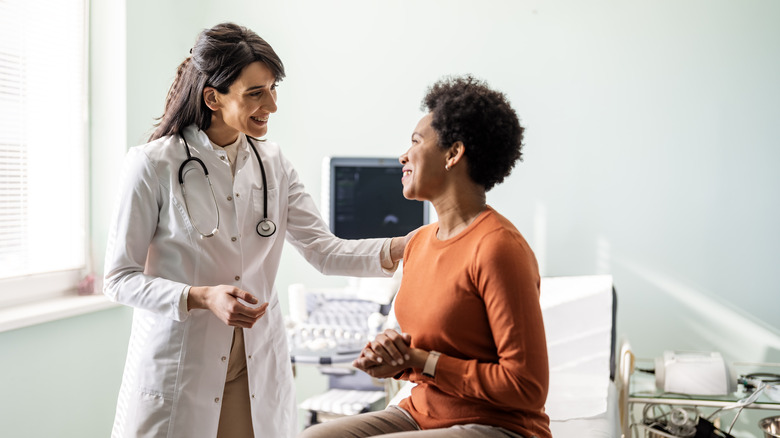 Doctor comforts a patient in exam room