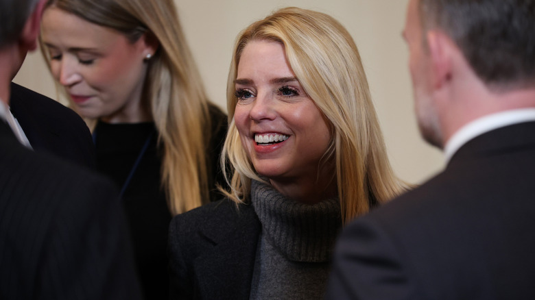 Pam Bondi smiles as she speaks to colleagues at an event