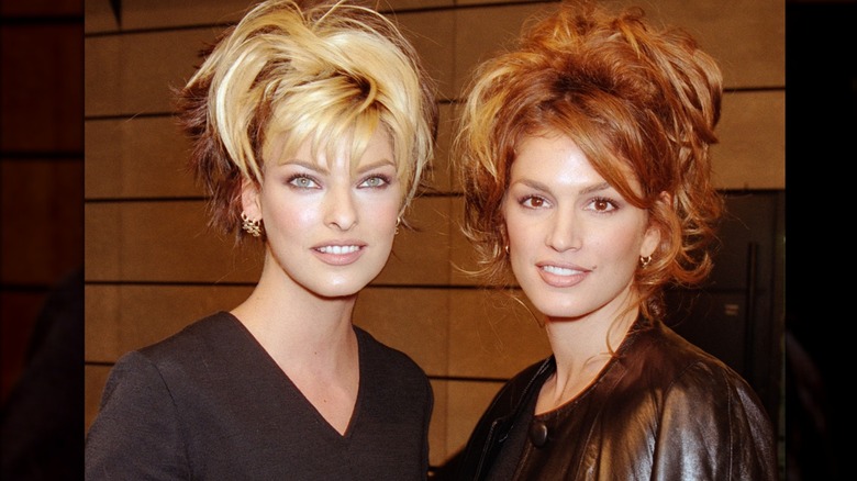 Linda Evangelista and Cindy Crawford pose backstage during Paris Fashion Week, 1995