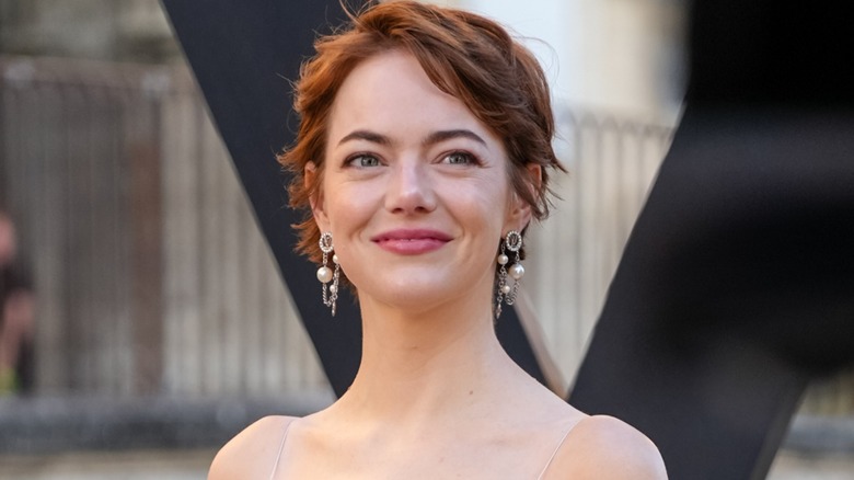 Emma Stone smiling on the red carpet in 2025