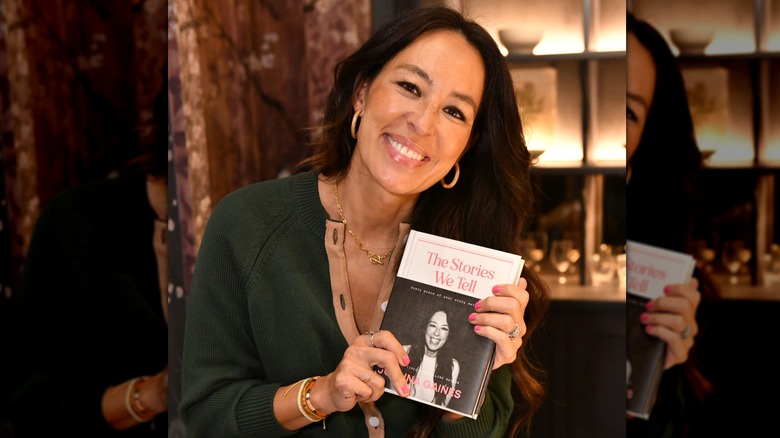 Joanna Gaines smiling while holidng up her biography