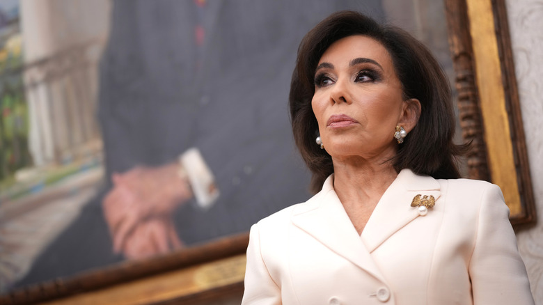 Jeanine Pirro looking serious and wearing a white suit