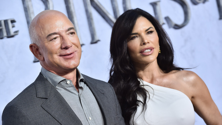 Lauren Sanchez Bezos on the red carpet in a white gown next to Jeff Bezos