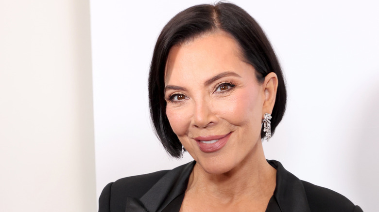 Kris Jenner smiling at the camera in a black blazer