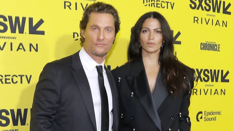 Camila Alves McConaughey and Matthew McConaughey on the red carpet in front of a bright yellow background