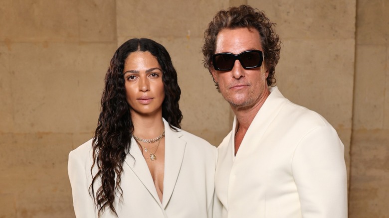 Camila Alves McConaughey and Matthew McConaughey wearing white and looking serious on the red carpet
