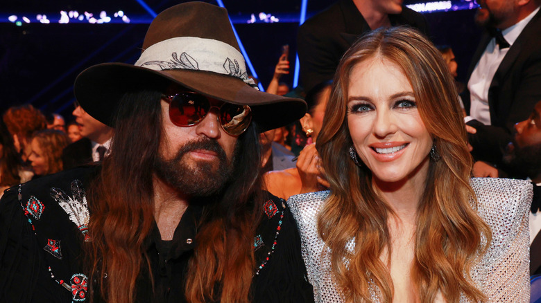 Elizabeth Hurley sitting next to Billy Ray Cyrus at an awards show