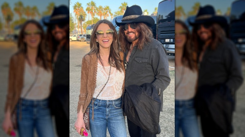 Elizabeth Hurley standing next to Billy Ray Cyrus outdoors