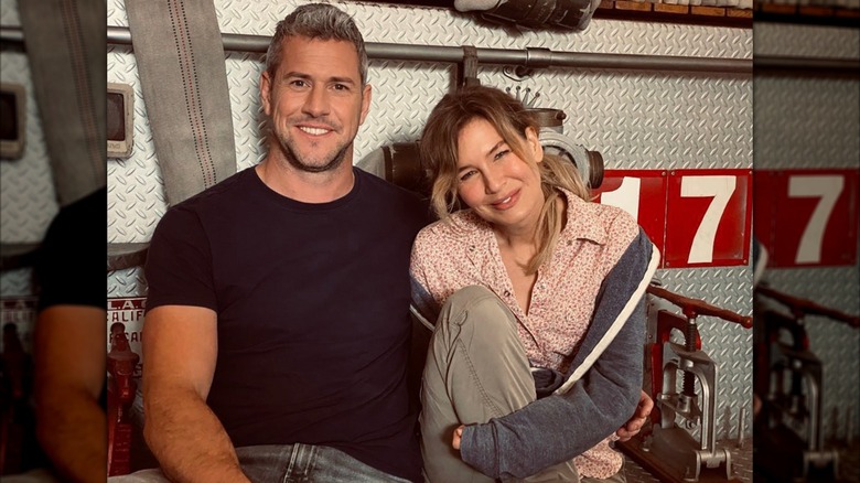 Ant Anstead with his arm around Renee Zellweger sitting in front of a fire truck