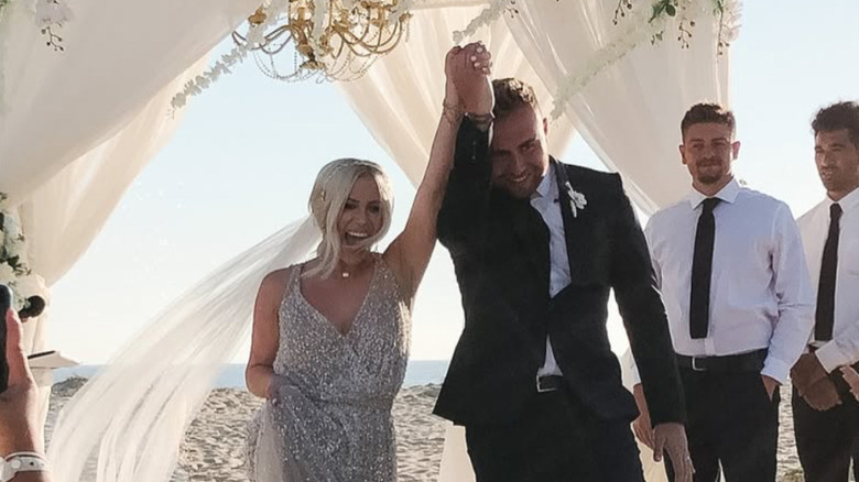 Jessi Draper and Jordan Ngatikaura hold hands on their wedding day