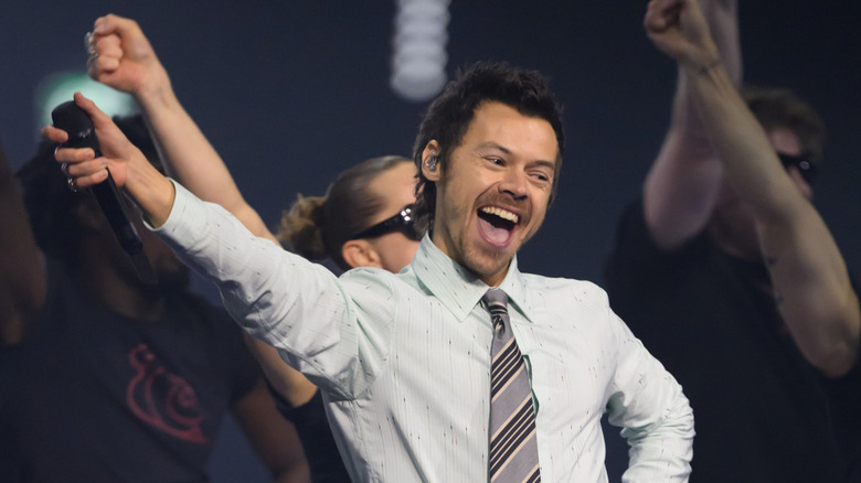 Harry Styles smiling while dancing on stage