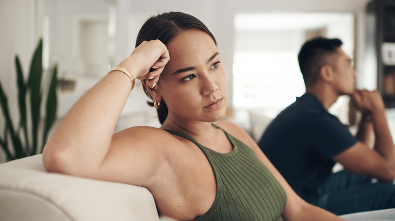 Frustrated couple sitting in the living room at home