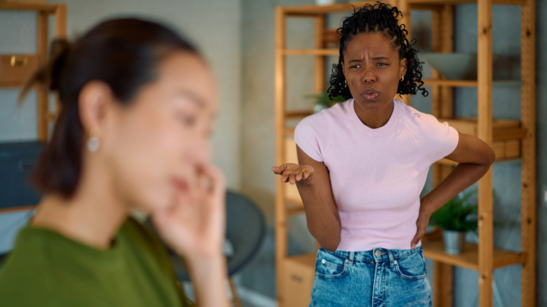 couple experiencing an argument at home, with one partner expressing frustration while the other looks away, highlighting communication issues and conflict in their relationship
