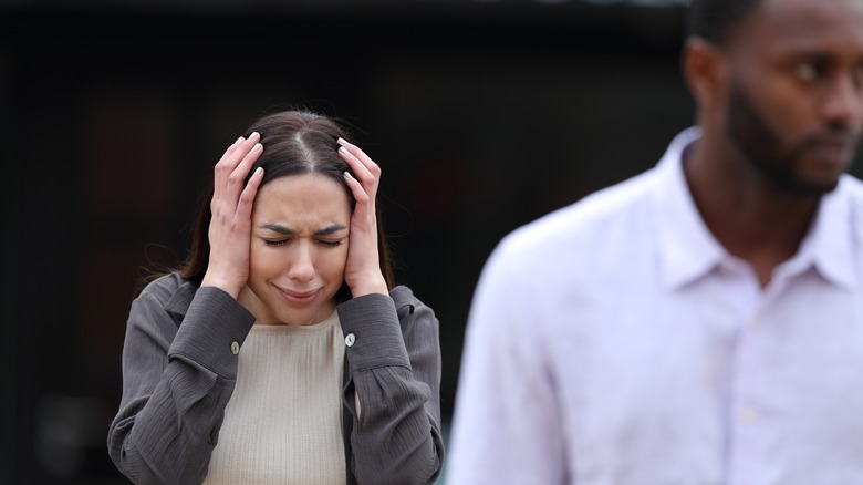 woman holding head in frustration