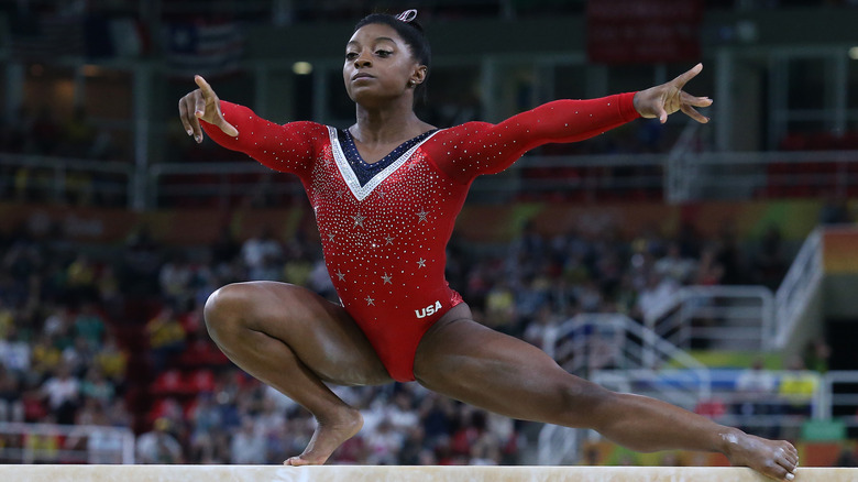 Simone Biles wears red leotard on balance beam at the 2016 Rio Olympics