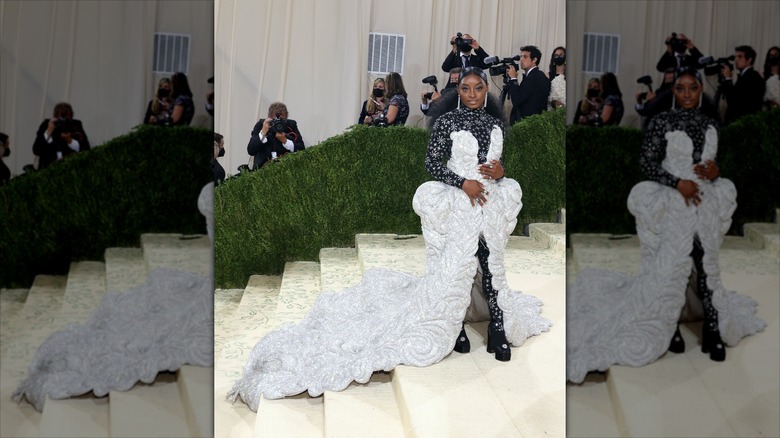 Simone Biles posing at the 2021 Met Gala in an extravagant, silver gown