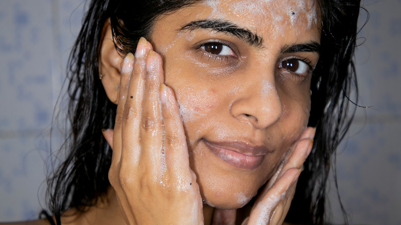 Woman applying moisturizer 